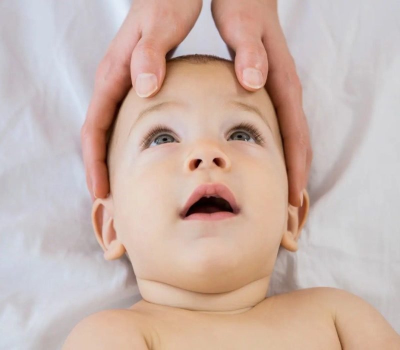 Bebé recibiendo una terapia craneosacral suave y segura en consulta especializada en Torrox. Técnica indicada para cólicos y alteraciones del sueño.